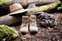 Botas de caminhada e trilby no chão da floresta musgosa — Fotografia de Stock