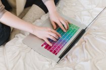 Mulher mãos digitando no laptop na cama — Fotografia de Stock
