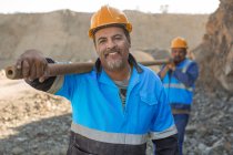 Portrait de travailleurs de carrière dans une carrière, portant un tuyau métallique — Photo de stock