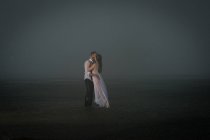 Casal molhado beijando na praia enevoada — Fotografia de Stock