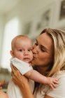 Frau küsst Baby-Tochter auf Wange — Stockfoto