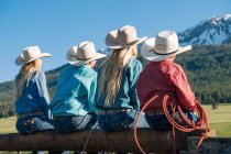 Visão traseira de cowboys e cowgirls em cerca, olhando para longe, Enterprise, Oregon, Estados Unidos, América do Norte — Fotografia de Stock