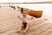 Portrait de bébé fille assis sur la jetée du lac — Photo de stock
