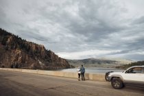 Couple standing on road beside Dillon Reservoir, looking at view, Silverthorne, Colorado, USA — Stock Photo