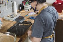 Juwelierin arbeitet in Werkstatt mit Werkzeug — Stockfoto