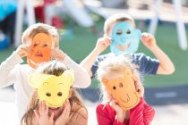 Portrait if four children wearing paper masks — Stock Photo