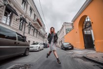 Frau überspringt Straße in Stadtstraße — Stockfoto