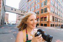 Молодая женщина на городской улице фотографирует — стоковое фото
