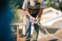 Workman standing on roof of house, preparing to install solar panels — Stock Photo
