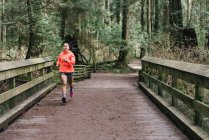 Front view of woman running in forest, Vancouver, Canada — Stock Photo