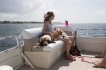 Donna e cane da compagnia si rilassano in barca — Foto stock