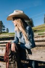 Cowgirl wearing cowboy hat leaning on fence, looking away, Enterprise, Oregon, United States, North America — Stock Photo