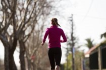 Vista posteriore della giovane donna che fa jogging — Foto stock