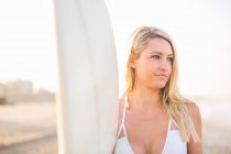 Jovem surfista feminina de biquíni com vista para a praia, Santa Monica, Califórnia, EUA — Fotografia de Stock