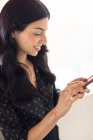Junge Geschäftsfrau schaut aufs Smartphone — Stockfoto