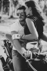 Giovane donna che abbraccia fidanzato in moto — Foto stock