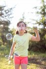 Junges Mädchen pustet Seifenblasen im Freien — Stockfoto