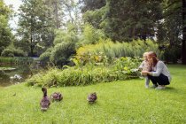 Mãe e filha de criança assistindo patos no parque — Fotografia de Stock