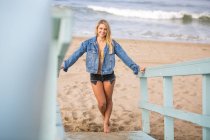 Portrait of long blond haired young woman by beach hut, Santa Monica, California, USA — Stock Photo