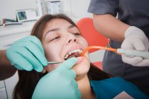 Dentista y enfermera dental con paciente - foto de stock