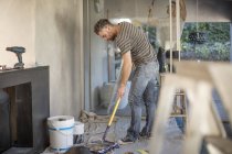 Zwei Männer in unmöbliertem Haus schmücken Wände — Stockfoto