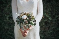 Sposa con bouquet da sposa con siepe sullo sfondo — Foto stock
