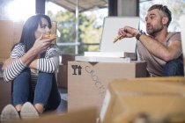 Paar isst Pizza im neuen Zuhause — Stockfoto