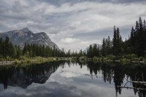 Reflexion von Bergen und Bäumen in See, Canmore, Kanada, Nordamerika — Stockfoto