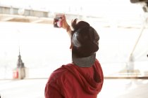 Молодий чоловік на відкритому повітрі, беручи селфі за допомогою смартфона, вид ззаду — стокове фото