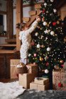 Young girl decorating Christmas tree — Stock Photo