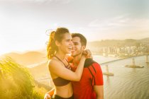 Man and woman runners hugging and smiling outdoors — Stock Photo