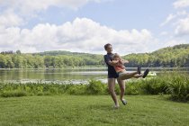 Ragazze che giocano sull'erba accanto al lago — Foto stock