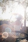 Jeune femme balançant sur jardin balançoire — Photo de stock