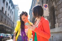 Женщины на перерыве с помощью мобильного телефона, Милан, Италия — стоковое фото