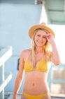 Porträt einer jungen Frau im Bikini bei einer Strandhütte, Santa Monica, Kalifornien, USA — Stockfoto