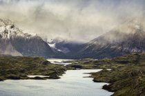 Nuage bas et rayons du soleil dans le paysage montagneux de la rivière, Parc national de Torres del Paine, Chili — Photo de stock