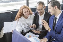 Бізнесмени і жінка дивиться на цифровий планшет на пасажирському поромі — стокове фото