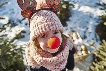 Girl in christmas tree forest with red nose, high angle portrait — Stock Photo