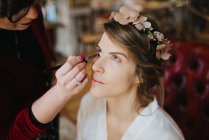 Noiva se preparando para o casamento com maquiador — Fotografia de Stock