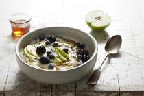 Greek yogurt with apple, blackberries, blue berries and honey — Stock Photo