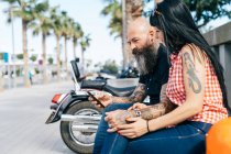 Reifes Hipster-Paar auf Bank mit Blick auf Smartphone, Valencia, Spanien — Stockfoto