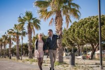 Paar spaziert durch palmen, cagliari, sardinien, italien, europa — Stockfoto