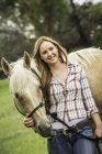 Portrait of young woman standing with horse — Stock Photo