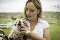 Молодая женщина с пальцем во рту щенка на ранчо, Бриджер, Монтана, США — стоковое фото
