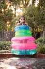 Menina em anéis infláveis que estão no lado da piscina exterior — Fotografia de Stock