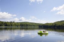 Three children on inflatable boat on lake — Stock Photo