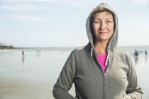 Retrato de mulher em top com capuz na praia — Fotografia de Stock