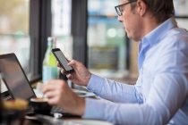 Человек в кофейне с помощью смартфона — стоковое фото