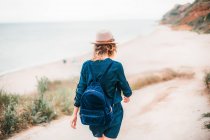 Vue arrière de la femme marchant vers la plage — Photo de stock