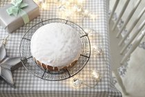 Gâteau glacé sur table avec lumières décoratives — Photo de stock